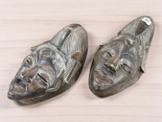 A pair of African carved hardwood masks, length 40 cm.