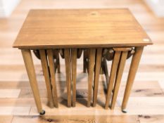 A teak occasional table with four folding nesting tables beneath, width 62 cm.