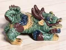 A 20th century Chinese polychrome earthenware temple dog figure, length 21 cm.