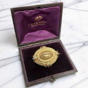 A Victorian Etruscan Revival pinchbeck brooch, with photograph verso in yellow metal surround,