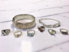 A silver hinged bangle, inscription dated 1974, a further silver bangle, five silver rings,