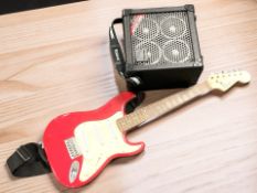 A Fender Squier Mini Stratocaster guitar and a Roland Micro Cube amplifier.