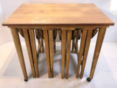 A teak occasional table with four nesting tables beneath, width 62 cm.