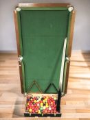 A 5ft 4 folding snooker table with cues, balls, etc.