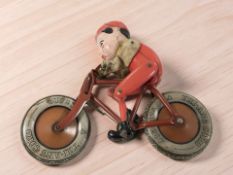 A mid-20th century Tri-Ang tin plate toy bicycle and rider, length 21 cm.