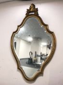 A 20th century gilt and bevelled cartouche shaped mirror, height 83 cm.