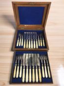 A mahogany cased canteen containing a twelve place setting of EPNS dessert cutlery with faux ivory