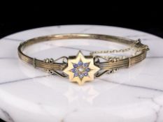 A late Victorian 9ct rose gold diamond and synthetic sapphire bangle,