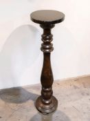 A reproduction turned and stained pine torchere, height 89 cm.