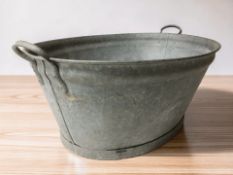 A galvanised twin handled wash tub, overall width 82 cm.