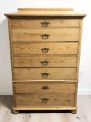 An early 20th century continental pine seven drawer chest, 102 cm x 52 cm x 152 cm.