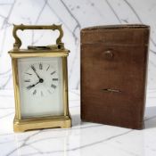 A brass cased carriage timepiece, height 14 cm including handle, with key and travel case.