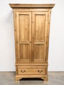 A modern pine two door wardrobe, 101 cm x 65 cm x 203 cm.