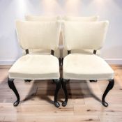 A contemporary set of four dining chairs on cabriole legs, in cream fabric.