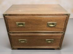 A mahogany campaign-style two drawer chest with brass pull handles, width 66 cm.