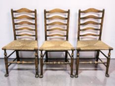 A set of three beech and rattan farmhouse ladderback chairs.