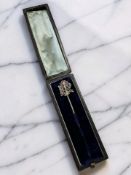 A diamond, ruby, and emerald stick pin with monogram finial, set in yellow gold,