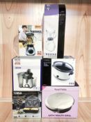 A group of boxed kitchen electricals including sandwich maker, slow cooker, blender, juicer, etc.