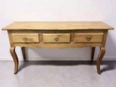 A 20th century French fruit wood three drawer dresser base, 150 cm x 43 cm x 77 cm.