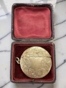 A 9ct gold circular vesta case with engraved foliate decoration,