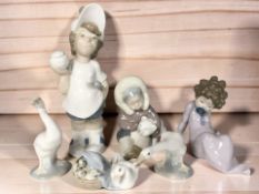 A Lladro figure of a boy holding a tennis racket and ball, Inuit child with polar bear cub,