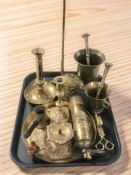 A group of brass wares including a desk flag pole, pricket candlestick, pestles and mortars, etc.
