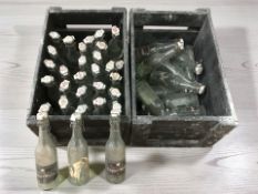 Two pine bottle crates containing assorted vintage Carlsberg glass bottles.