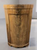 A pair of early 20th century continental flame mahogany bow front single door corner cabinets,