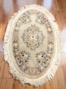 A Chinese oval woolen rug, 175 cm x 112 cm.