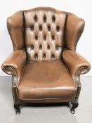 A 20th century Chesterfield buttoned brown leather wingback armchair, width 88 cm.