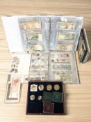 A collection of world bank notes in albums, gold plated crown sized coins,