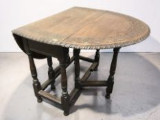 An Edwardian carved oak drop leaf gateleg table, width 91 cm.