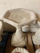 A concrete hexagonal bird bath,