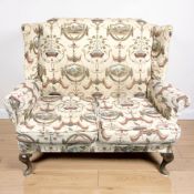 A 20th century two seater wingback settee on cabriole legs, width 123 cm.
