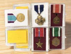 A group of medals including Coast Guard Distinguished Service medal, Navy Cross medal, U.