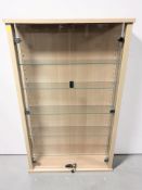 A contemporary glazed display cabinet with internal shelves and key, 68 cm x 20 cm x 112 cm.
