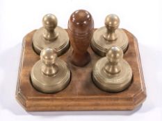 A set of Martin Bohill brass map/paper weights, on mahogany stand, width 18 cm.