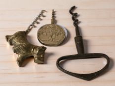 Three vintage corkscrews, one in the form of a scottie dog.