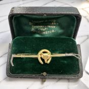 A 9ct gold and silver fox and riding crop bar brooch, length 5.