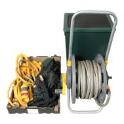 A hosepipe on reel, attachments, a plastic water tank.