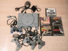 A Sony Playstation 1 with leads, controllers and various games.
