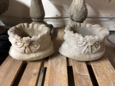 A pair of concrete sack planters,