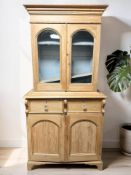 A Victorian glazed pine double door bookcase with moulded glass handles,