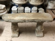 A log effect concrete garden bench on squirrel supports,