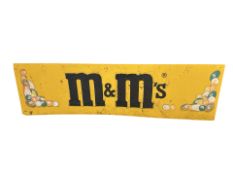 A large metal sign with later-applied M&M's advertising,