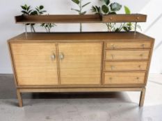 A 20th century teak cocktail sideboard, fitted cupboards and drawers with shelf above,