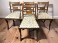 A set of four Regency-style mahogany and brass inlaid dining chairs.