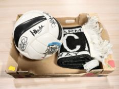 A Newcastle United scarf and a football bearing various signatures.