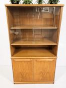 A teak sliding glass door bookcase fitted cupboards beneath, 68 cm x 35 cm x 124 cm.