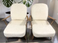 A pair of 20th century Ercol stained beech armchairs with cream floral cushions, width 73 cm.